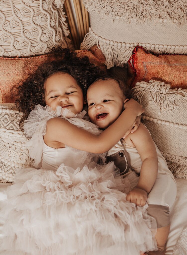 Newborn photography Melbourne with baby and older sibling cuddling together